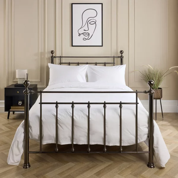 Hotel Pure Luxury cotton rich percale extra long duvet cover on a metal framed bed in a contemporary bedroom. There are also pillows on the bed. There is a dark wood cabinet with a lamp on top on the left-hand side of the room, with a painting above the bed.
