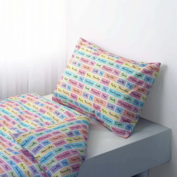 A multi-coloured pillowcase and duvet cover set from Rachel Riley. It features a series of coloured squares that include motivational slogans such as 'peace and joy' and 'keep calm'.