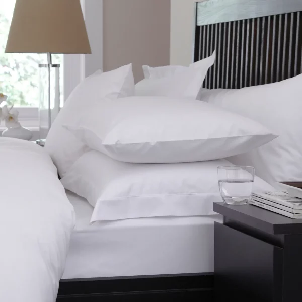 Close up of Martex Sestina White Pillowcases covering pillows on a bed