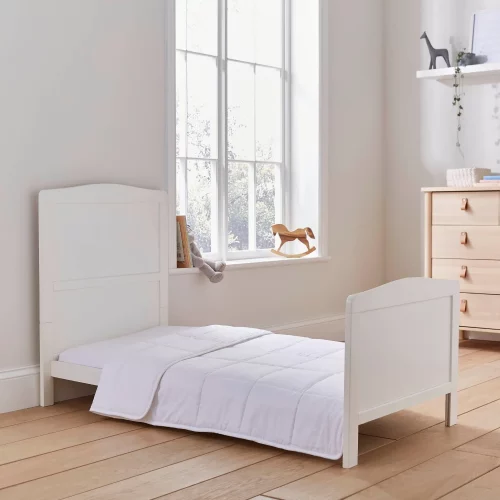 A Martex Baby temperature regulating 4 tog cot bed duvet sitting on a bed in a child's bedroom.