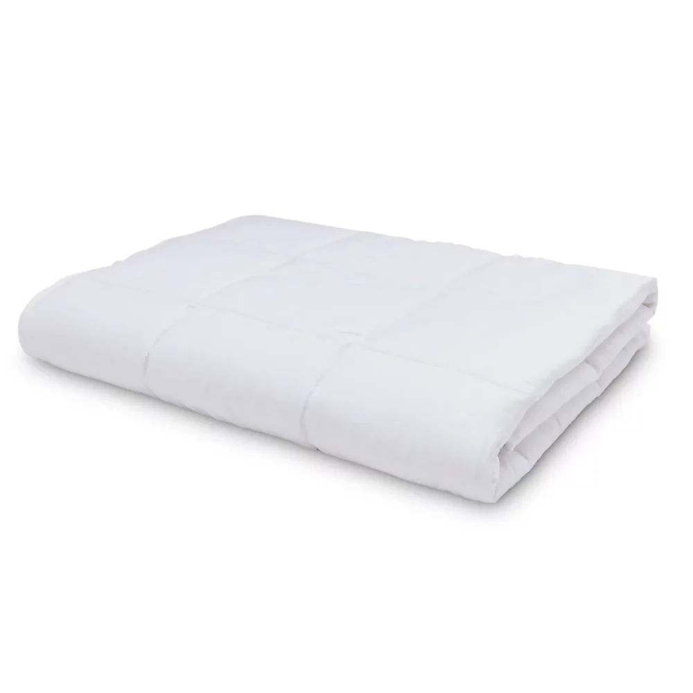 An temperature regulating 4 tog cot bed duvet from Martex Baby on a white background. The duvet is folded up.