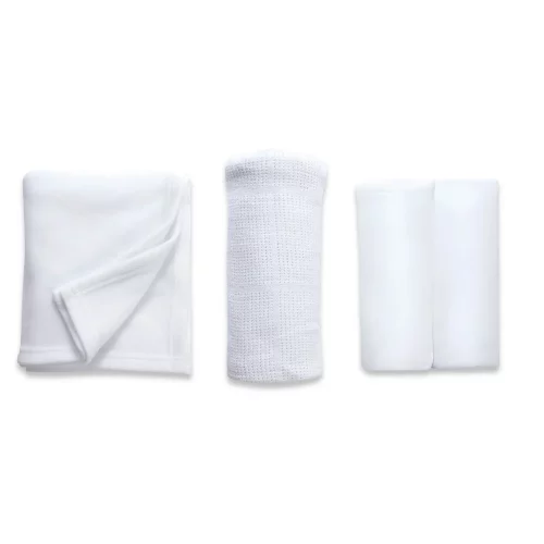 A white cot bed starter set from Clair De Lune. It contains a fitted sheet, cellular blanket, and polar fleece blanket.