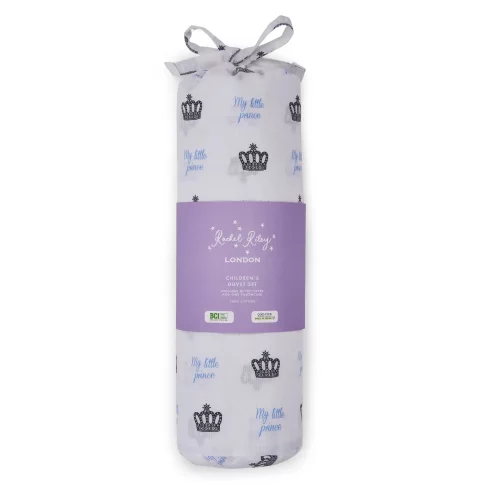 A white duvet cover and pillowcase set from Rachel Riley in its packaging. It comes in a bag which features a print of small crowns all across it with blue writing that says 'My Little Prince'.
