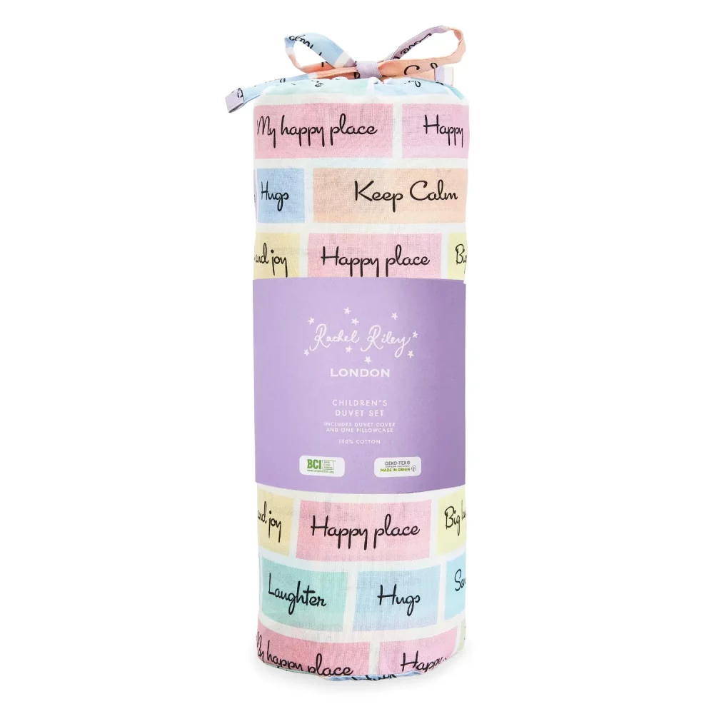A multi-coloured pillowcase and duvet cover set from Rachel Riley in its bag packaging. It features a series of coloured squares that include motivational slogans such as 'peace and joy' and 'keep calm'.