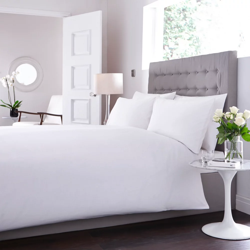 Sestina White Duvet Cover on a bed in a brightly lit bedroom