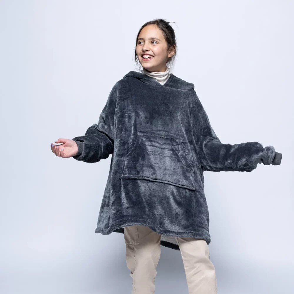 An female child wearing a Hudi wearable blanket in charcoal.