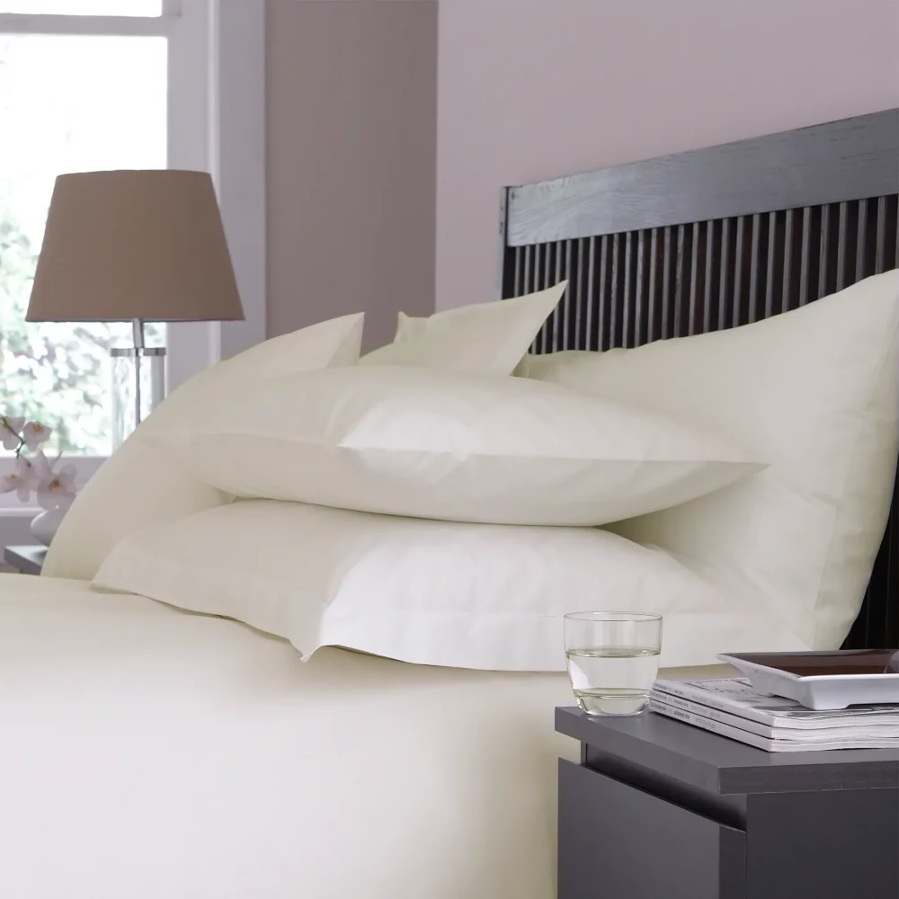 Close up of Martex Sestina Ivory Pillowcases covering pillows on a bed