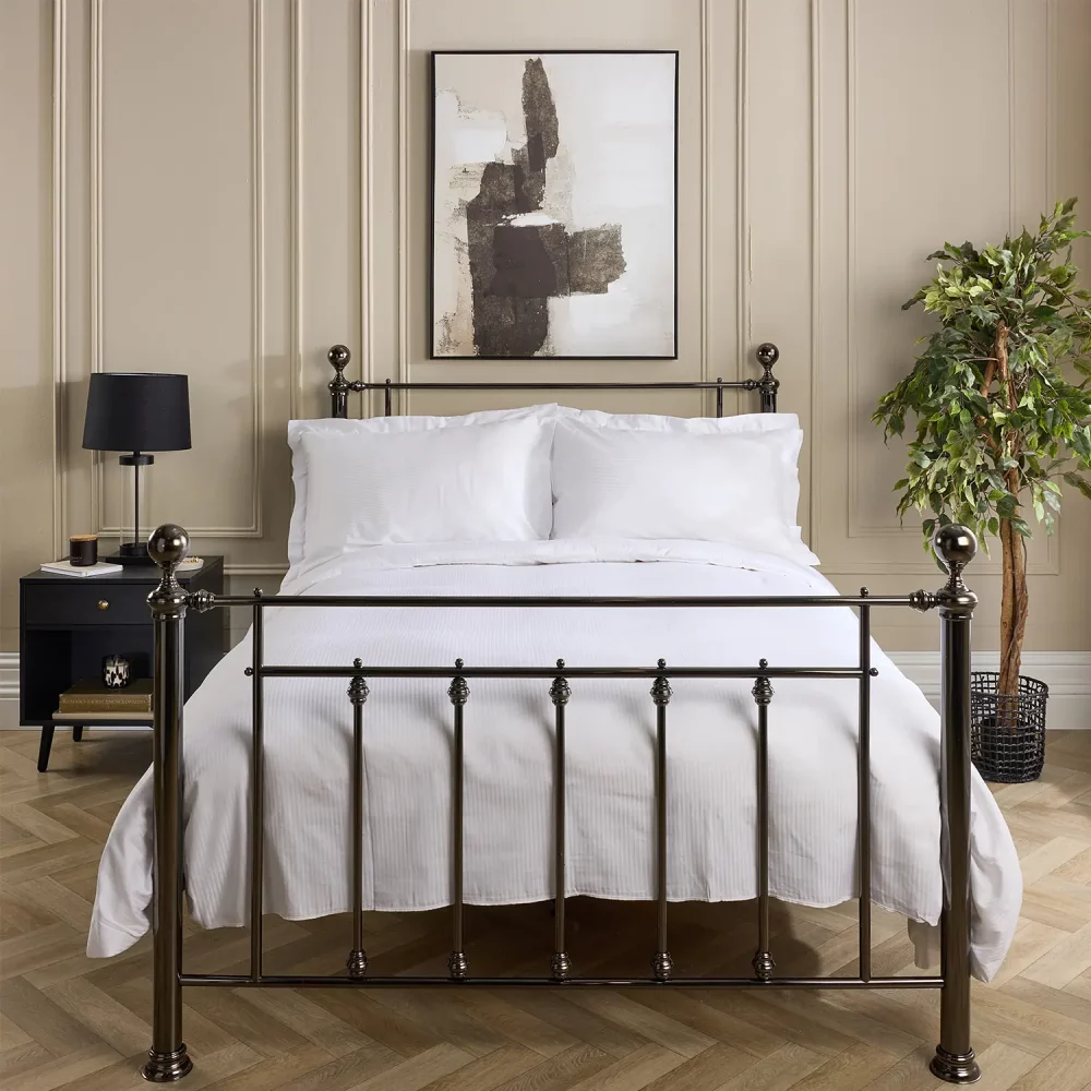 A Hotel Pure Luxury cotton rich percale satin stripe duvet cover on a bed, complete pillows and pillowcases. There is a dark wood bedside cabinet with a lamp sitting on top of it next to the bed. You can see a contemporary painting above the metal framed bed.